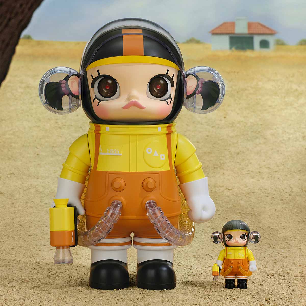 Squid Game SPACE MOLLY Young-hee figure in yellow and orange outfit with small figure on sandy landscape